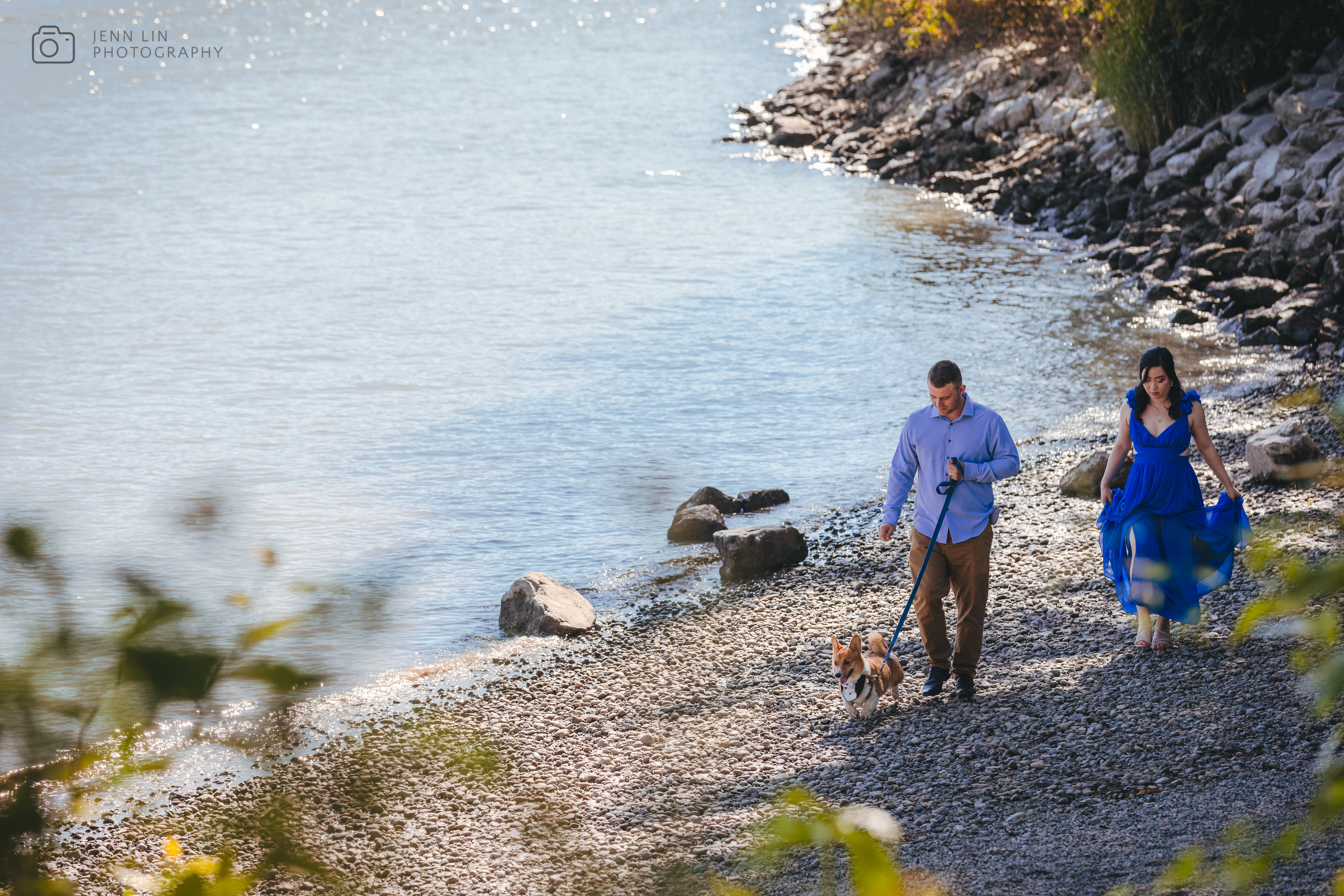 Tyler and Tiffany walk their Corgi, Benny, along a riverside beach on a sunny July day in the Fraser River District in Vancouver, BC. Photo by Jenn Lin © 2024, All Rights Reserved.