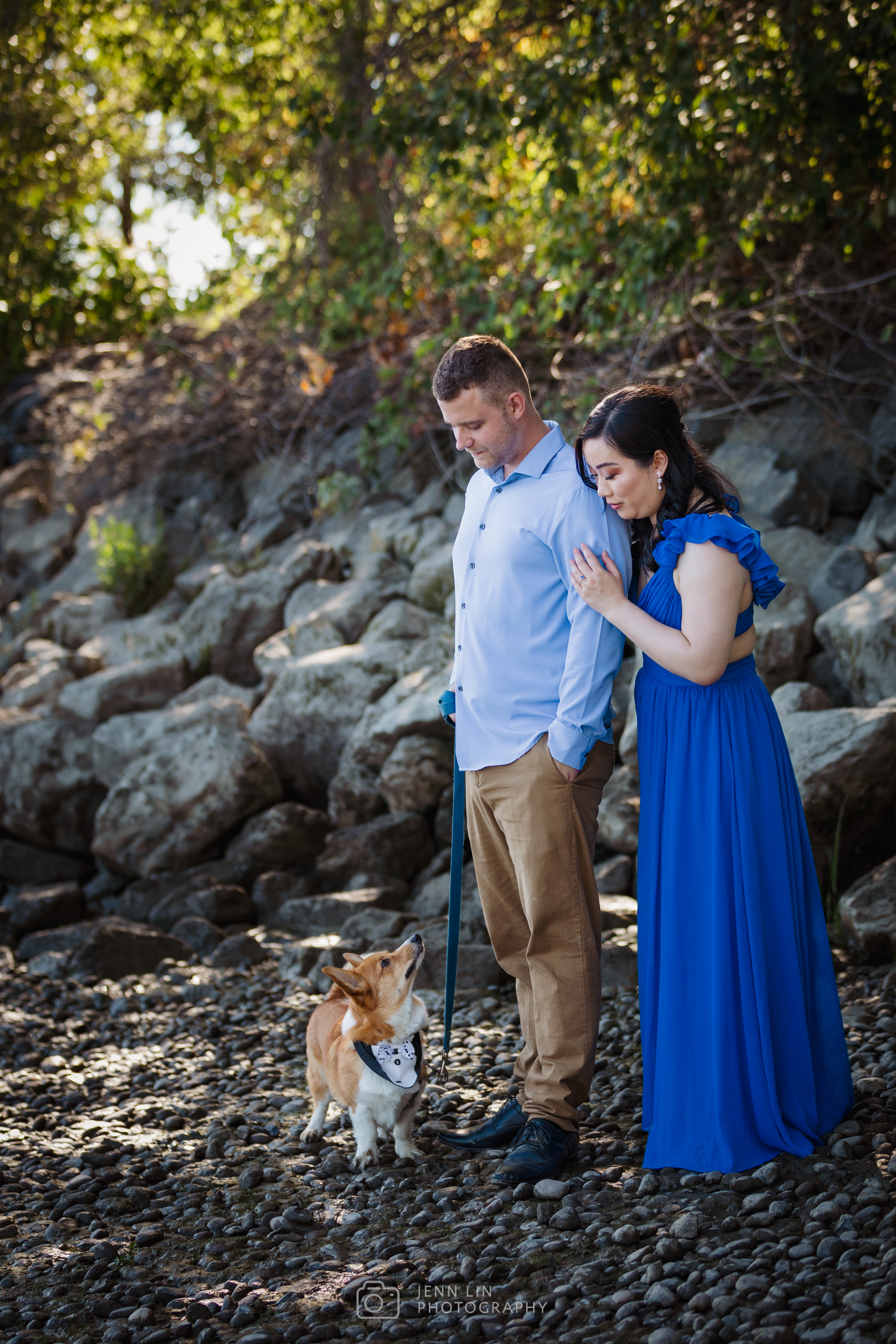 Benny the Corgi looks up at his owners as his owners look down at him. Shot on a beach found within the River District in Vancouver, BC. Photo by Jenn Lin © 2024, All Rights Reserved.